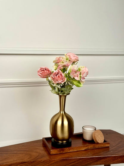 High Objects Solara Sculpted Vase in brushed gold metal with a rounded body and slender neck, holding pink floral arrangement.