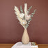 High Objects Solora Vase, a teardrop-shaped natural clay vase with a textured finish, holding dried bunny tail grass in tan and mint green.