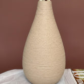 High Objects Solora Vase, handcrafted natural clay with teardrop silhouette, holding dried pampas grass and eucalyptus.