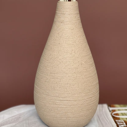 High Objects Solora Vase, handcrafted natural clay with teardrop silhouette, holding dried pampas grass and eucalyptus.