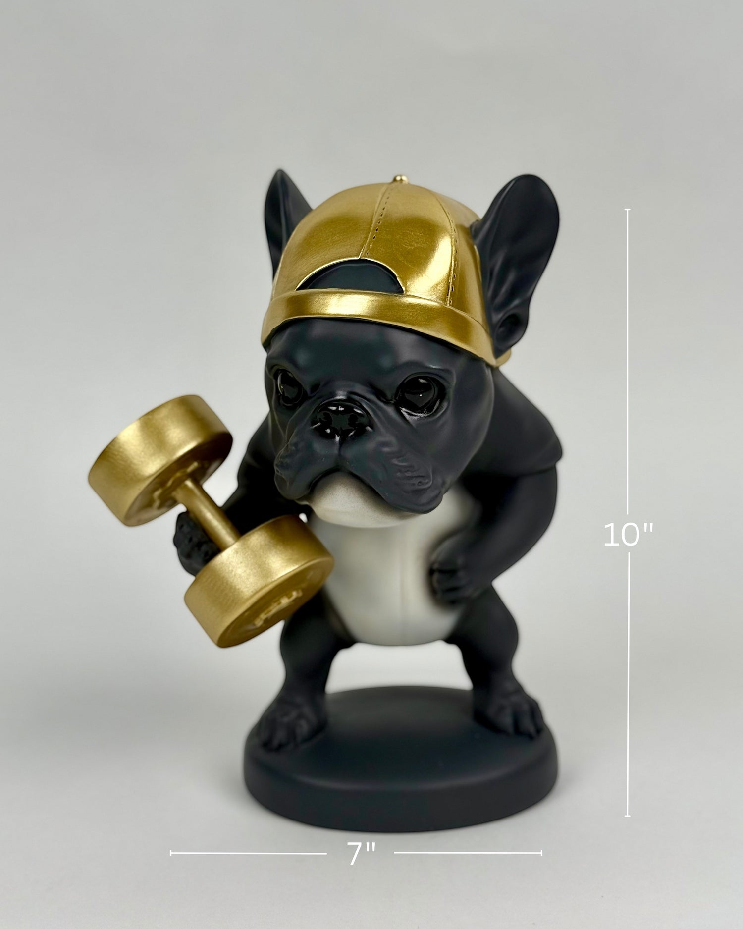 High Objects Sport Bulldog showpiece in black and gold, lifting a dumbbell, wearing a backward cap.