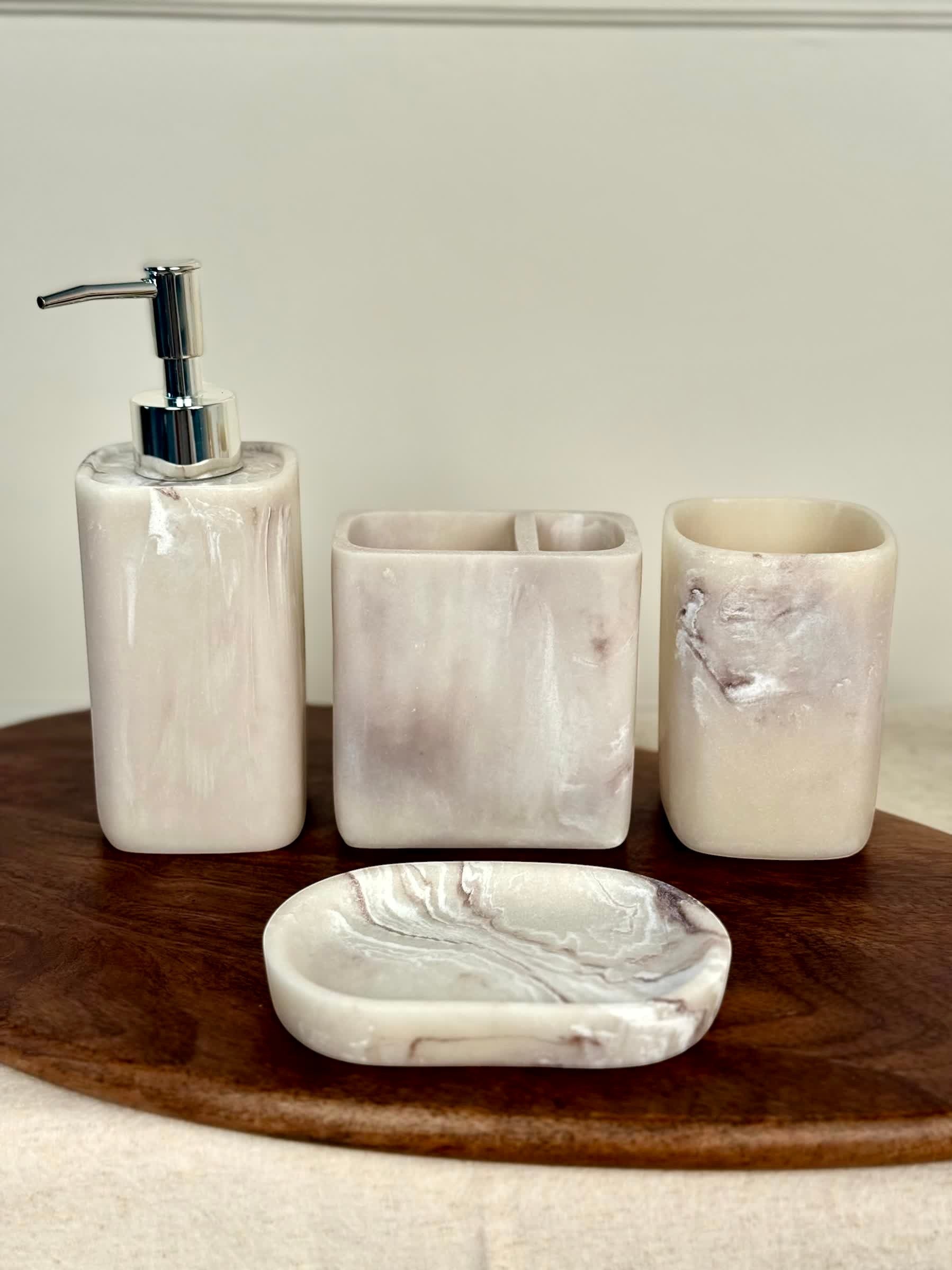 High Objects Stoneaura Bathroom Accessory Set: lotion dispenser, toothbrush holder, cup, and soap dish in marbled cream and taupe resin.