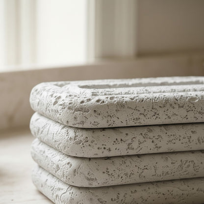 High Objects stacked stone tissue box holder with white tissues peeking out, on a marble countertop.