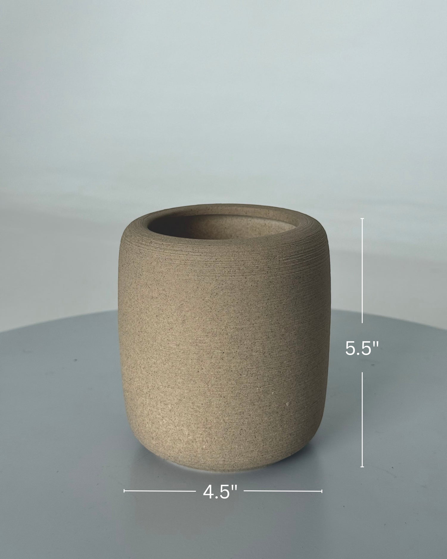 High Objects StoneAura ceramic vase in a natural earthy tone with a matte finish. Cylindrical shape, 5.5" H x 4.5" D.