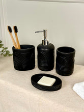 High Objects Stratacurve black bathroom accessory set with soap dish, dispenser, and toothbrush holder featuring carved grooves.