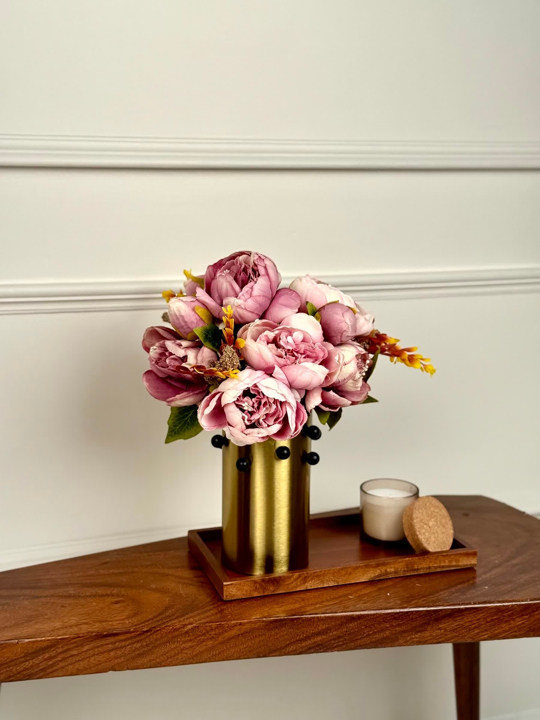 High Objects Studform Metal Vase in brushed gold with black studs, holding pink peonies. Modern sculptural decor.