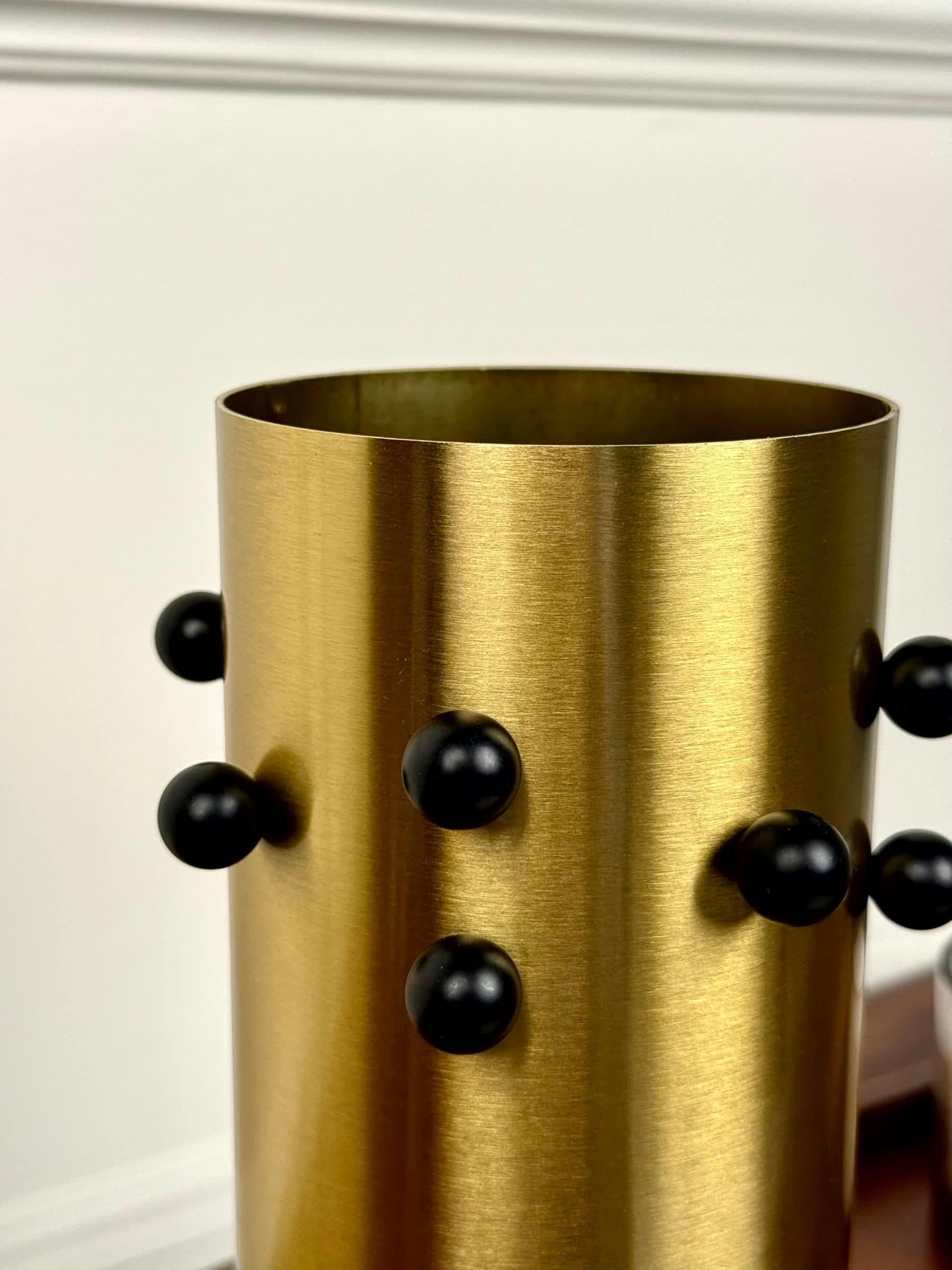 High Objects Studform Metal Vase in brushed gold with black stud accents. Cylindrical, modern design.
