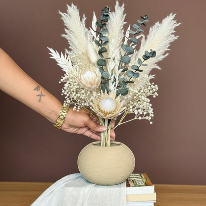 High Objects TerraSphere Ceramic Vase, a spherical beige vase with an earthy texture, holding a dried floral arrangement.