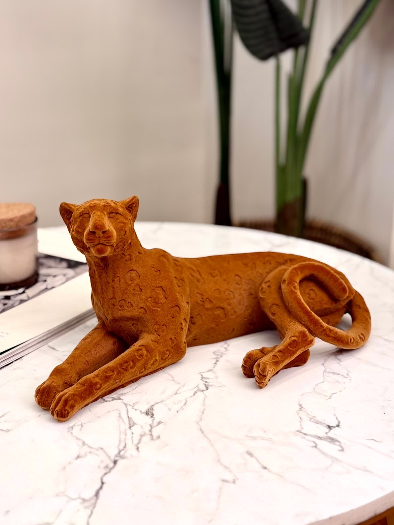High Objects terracotta cheetah showpiece sculpture with carved detailing, resting on a marble surface.