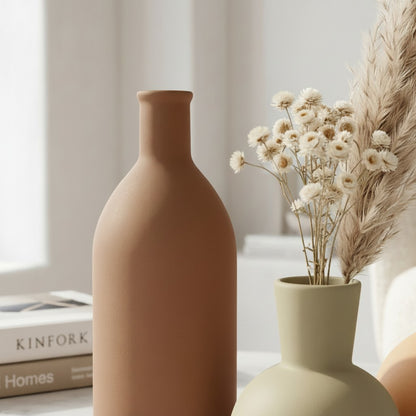 High Objects matte terracotta vase with a leather tag and dried flowers. Minimalist decor.