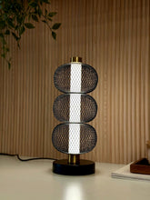 High Objects Trinity Mesh Table Lamp with stacked black lattice spheres and brushed gold accents.