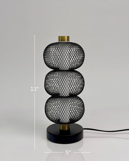 High Objects Trinity black mesh table lamp with three stacked spheres and brushed gold accents. Modern sculptural design.