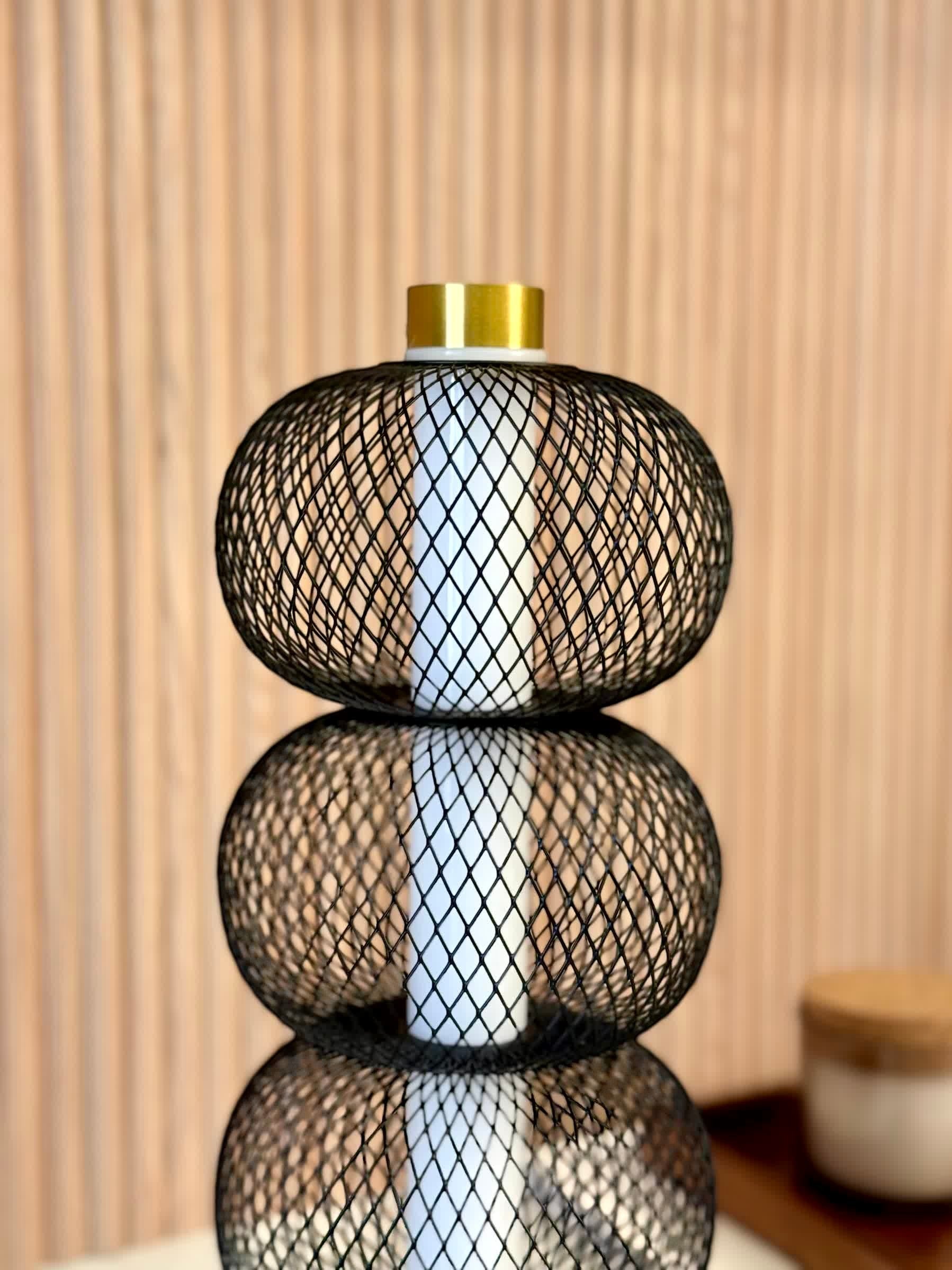 High Objects Trinity Mesh Table Lamp with stacked black mesh spheres and brushed gold accents.