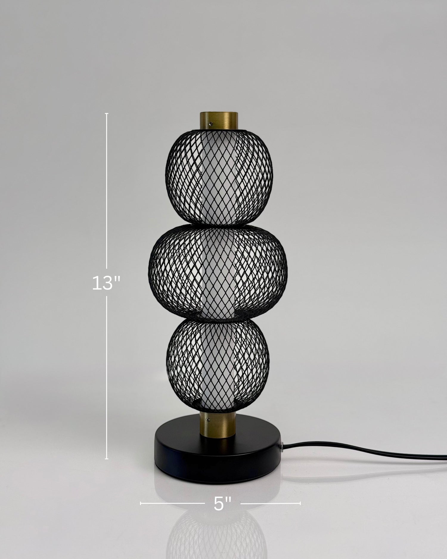 High Objects Trinity Slim Mesh Table Lamp with stacked spherical black mesh shades and brass accents.