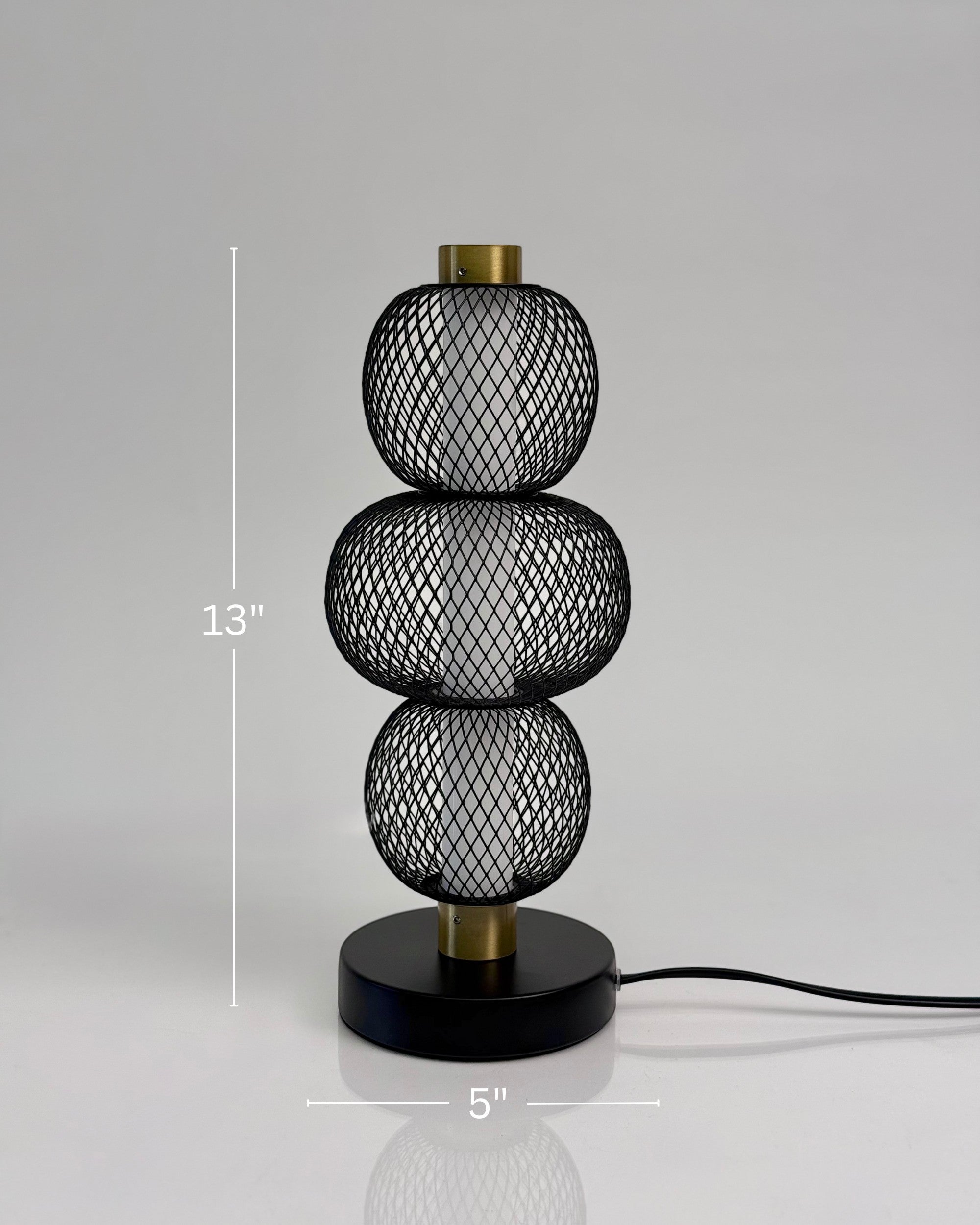 High Objects Trinity Slim Mesh Table Lamp with stacked spherical black mesh shades and brass accents.