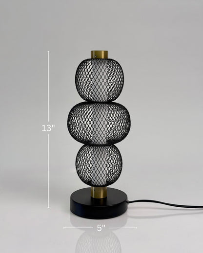 High Objects Trinity Slim Mesh Table Lamp with stacked spherical black mesh shades and brass accents.