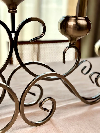 High Objects Valencia Scroll Five-Arm Candle Stand in antique bronze with ornate scrollwork and glass candle holders.