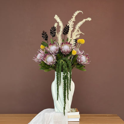 High Objects Volara Vase in pale mint green ceramic with a twisted, fluid design, holding dried floral arrangement.