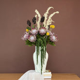 High Objects Volara Vase in pale green ceramic with twisting lines, holding a floral arrangement.