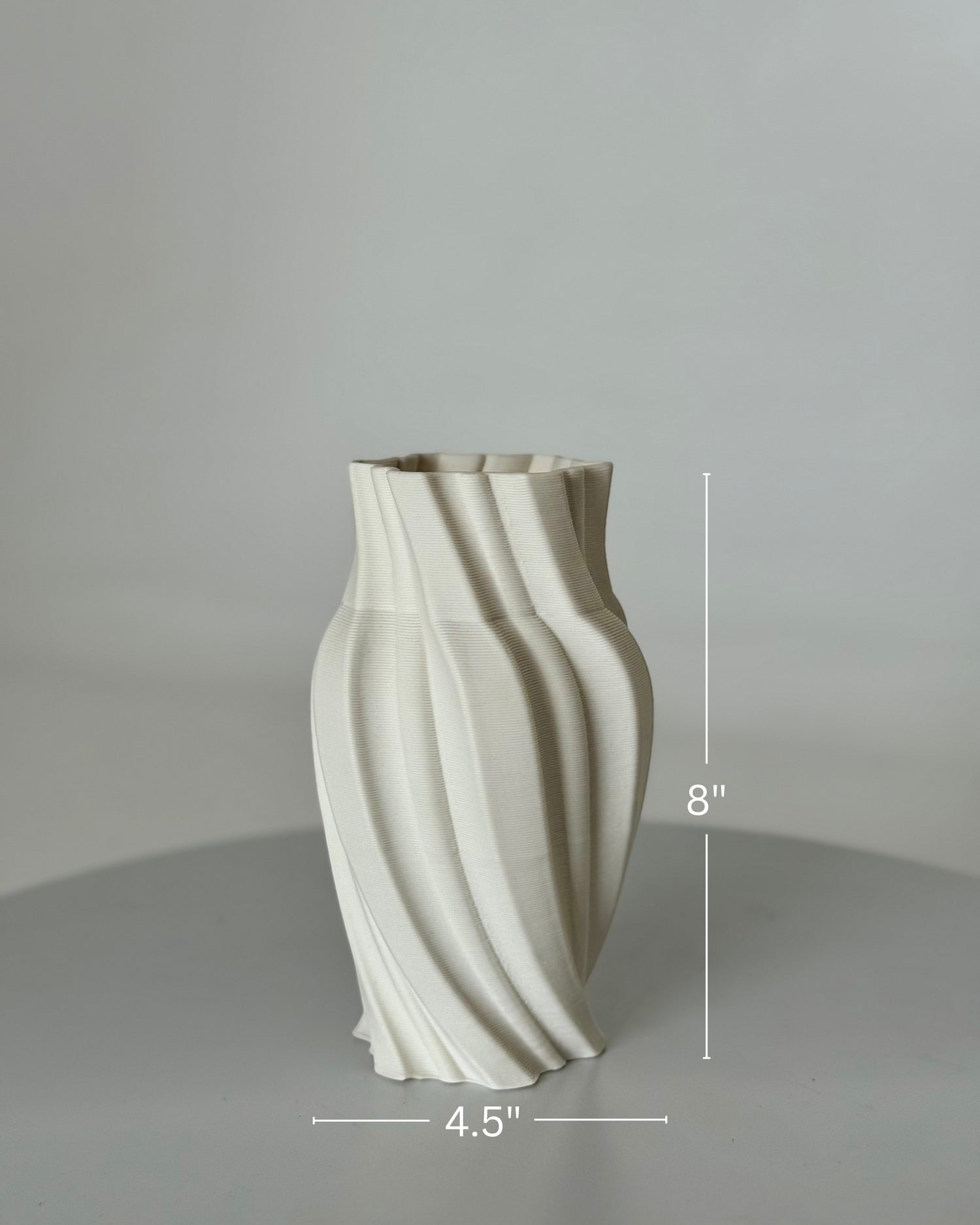 High Objects Volara Vase, a white ceramic vase with a matte finish and a twisting, fluid design. 8" H x 4.5" W.