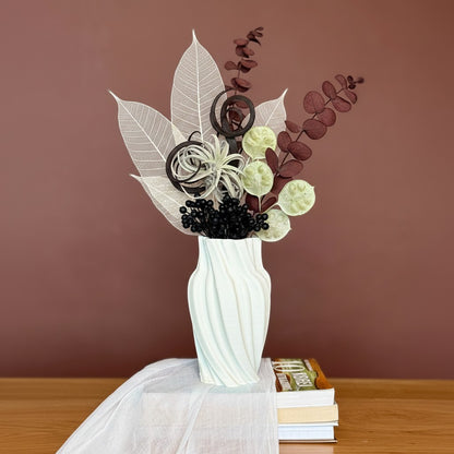 High Objects Volara Vase, white ceramic with a matte finish, featuring a twisting, fluid design. Holds dried floral arrangement.