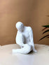 High Objects white textured polyresin abstract faceless figure in a contemplative pose, 8.5-inch sculpture.