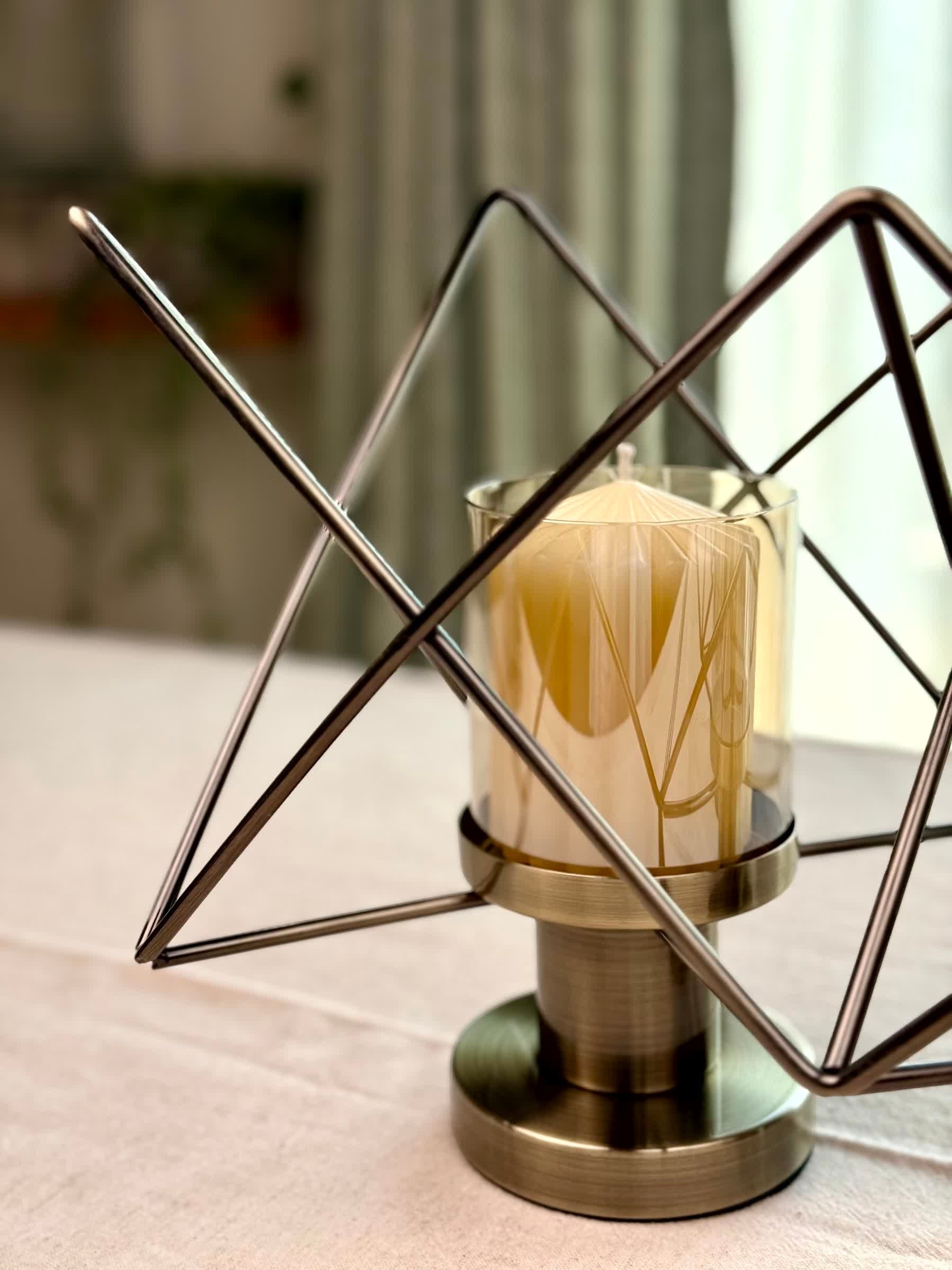 High Objects Zigzag Geo candle stand set with bronze metal frame and amber glass holder, holding a cream candle.
