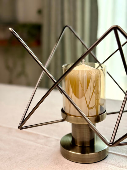 High Objects Zigzag Geo candle stand set with bronze metal frame and amber glass holder, holding a cream candle.