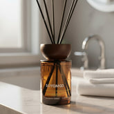 High Objects compact brown glass reed diffuser with oriental wood scent, 110ml capacity, on a marble countertop.
