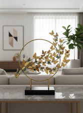 High Objects gold metal showpiece with a circular frame and a branch adorned with numerous golden butterflies.