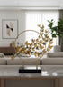 High Objects gold metal showpiece with a circular frame and a branch adorned with numerous golden butterflies.